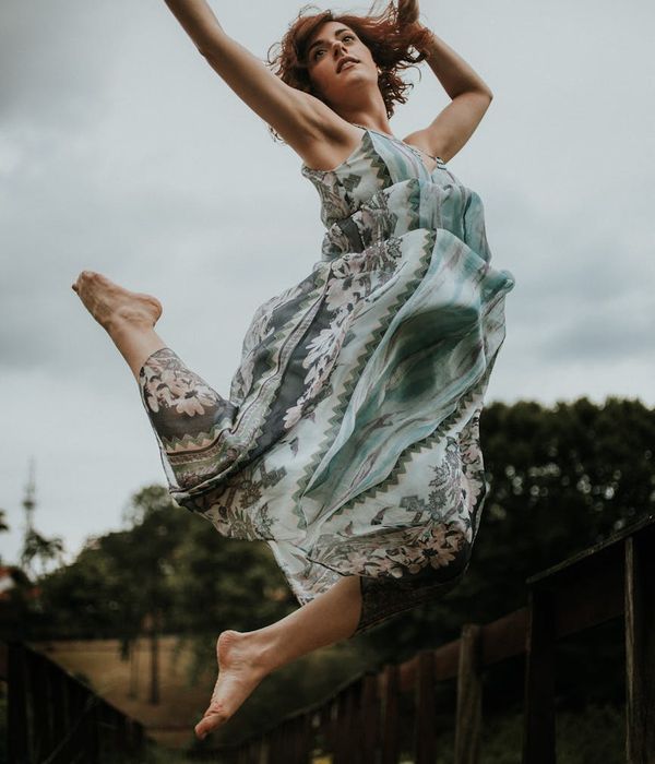 Person performing a flowing, graceful movement outdoors at sunrise.